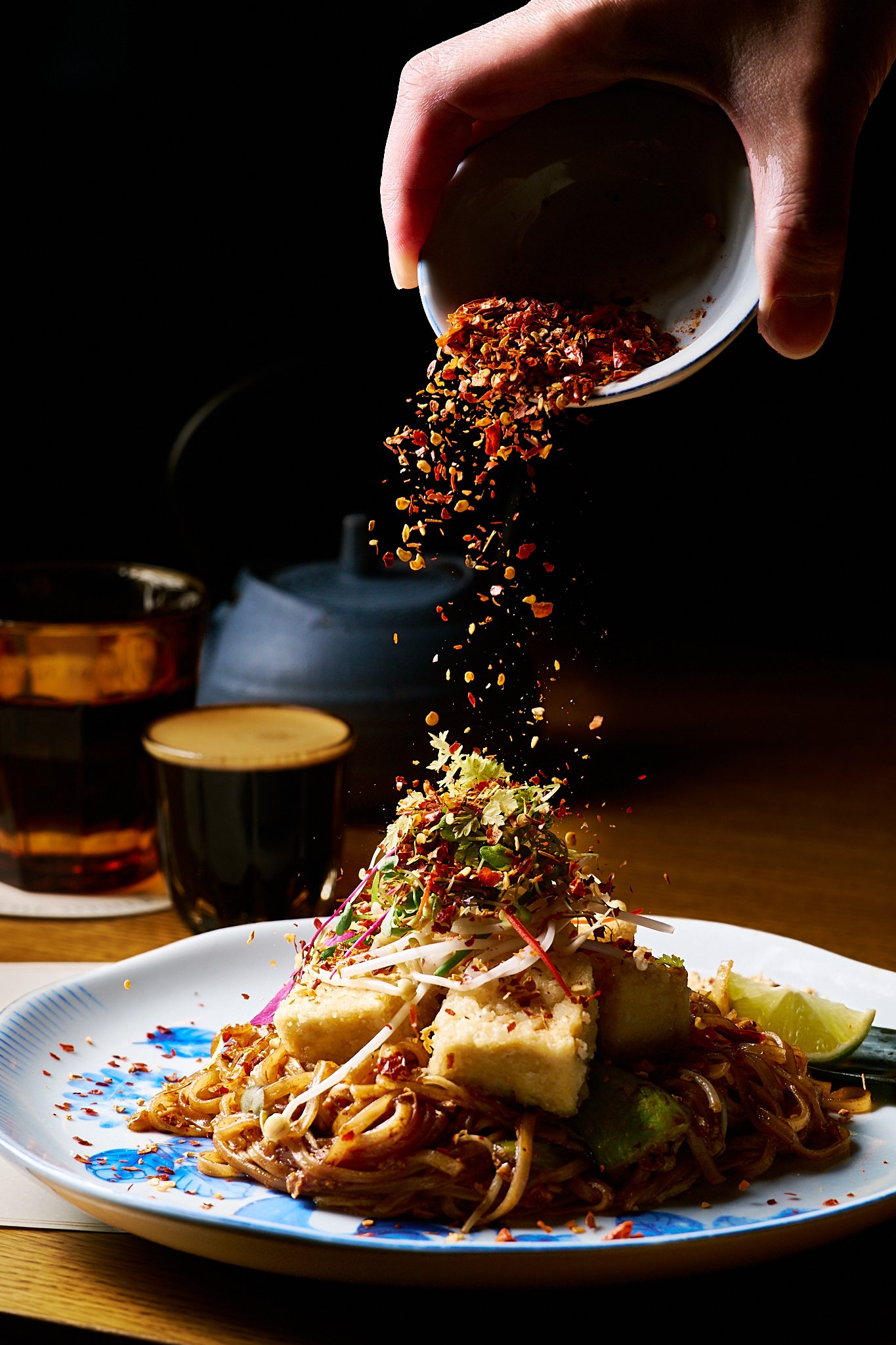 Sauce being poured over freshly prepared Pad Thai at The other ONE